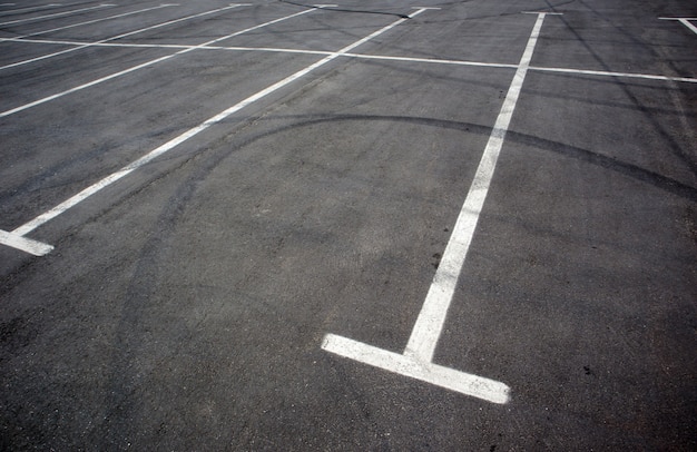 Parkeerzuilen op de parkeerplaats, gemarkeerd met witte lijnen. Lege parkeerplaats. Buitenparkeerplaats met vers geschilderde kiosklijnen. Buiten parkeren op een asfaltweg.