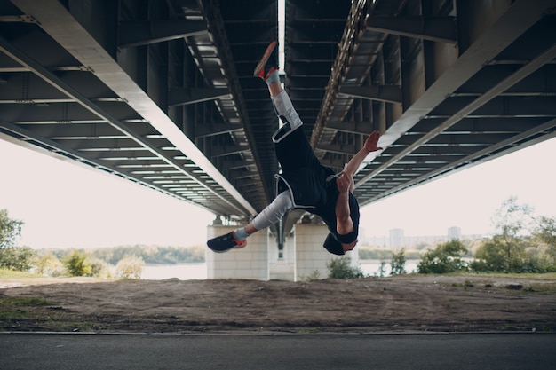 Parkour jonge man die acrobatische truc maakt en hoog springt