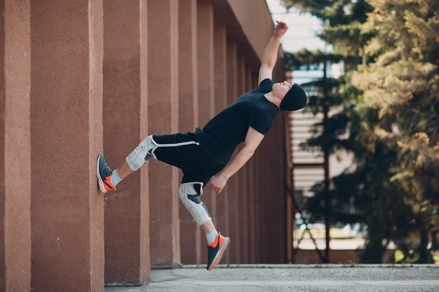 Parkour young man making acrobatic trick and flip jumping high