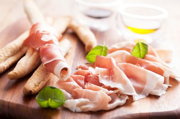 Photo parma ham and grissini bread sticks