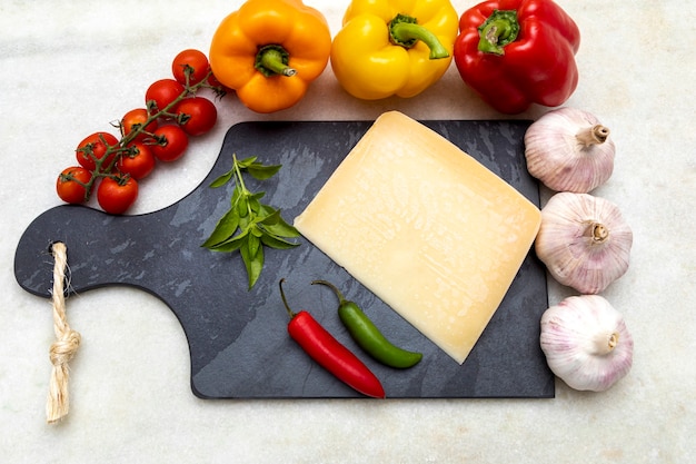 Parmesan cheese on black stone board with spices