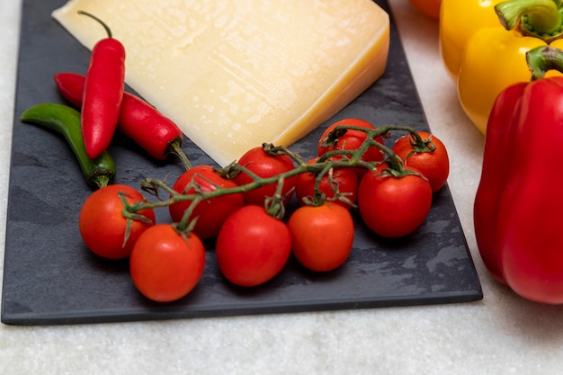 Parmesan cheese on black stone board with spices