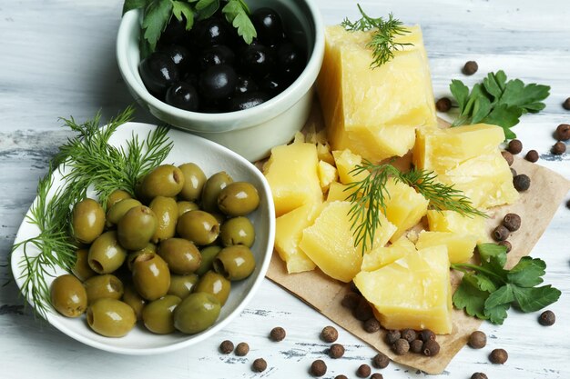 Parmesan cheese fresh herbs and olives on wooden background