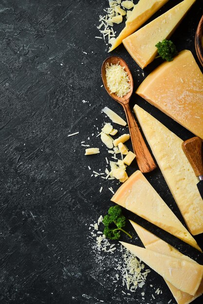 Parmesan cheese and snacks on a stone table Top view On a concrete background