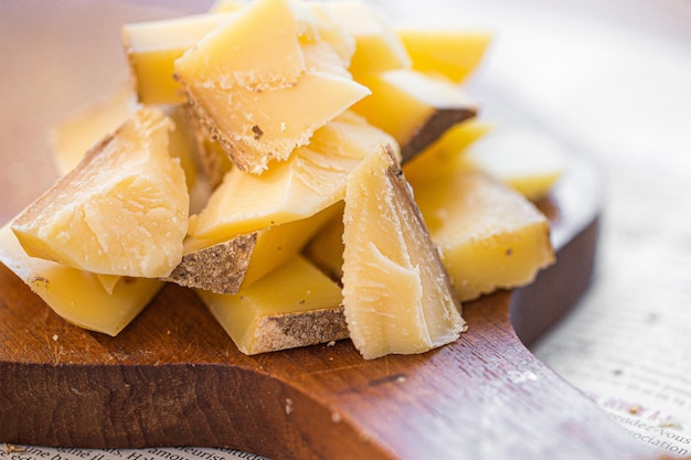 Fette di parmigiano sul tagliere. pezzi di formaggio sulla tavola. formaggio a pasta dura per vino