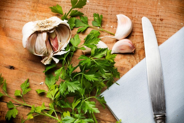 Parsley and garlics on a wooden table