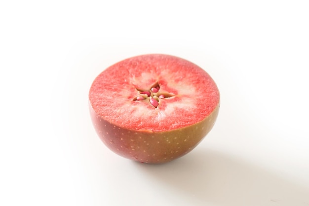 A part of an apple with red flesh inside isolated on a white Side view Seeds Central Asia Healthy food