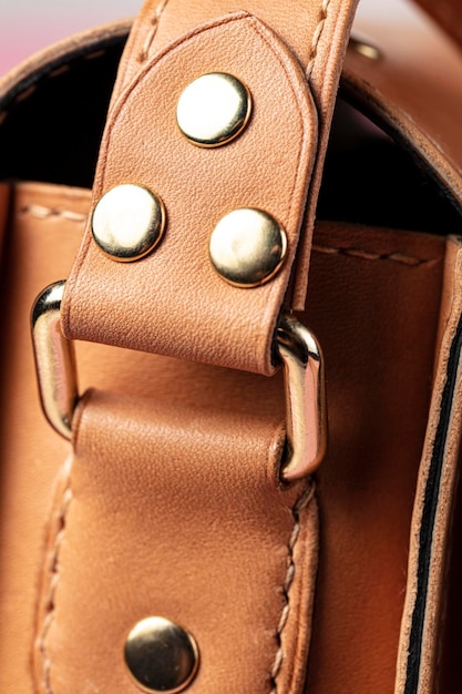 Part of a bag made of brown genuine leather with a metal fastening for the handle