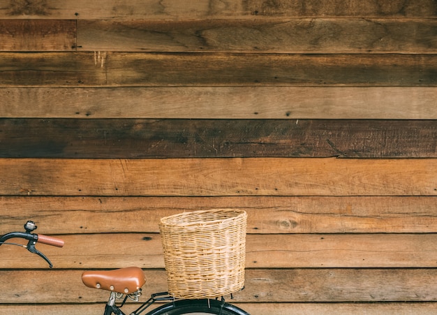 Part of bicycle with basket on wooden house wall