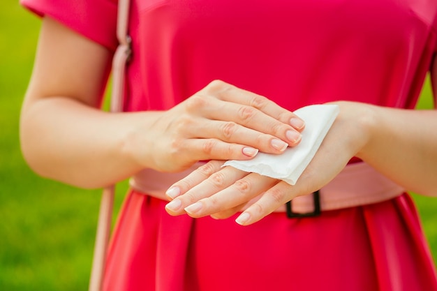 Part of the body of a young woman in a pink park . girl using wet wipes the sweat at hands