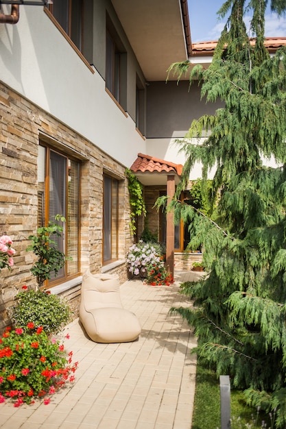 Part of the brick wall of the house, and the flowerpots with flowers standing next to it