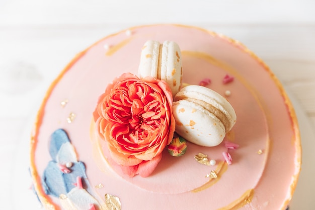 Part of cake.Light pink with flowers and macaroons.Top view