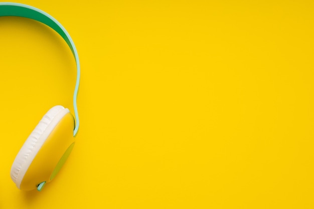 Part of colorful wireless headphones isolated on yellow background