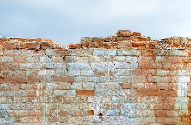 Parte del muro di mattoni distrutto, una magnifica tenuta. la superficie ha motivi decorativi. mattoni di varie forme e dimensioni.