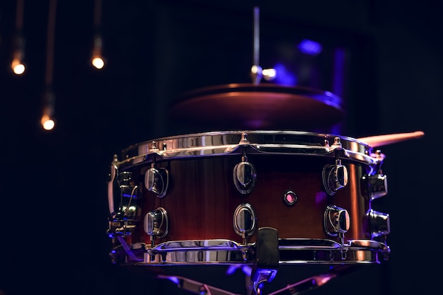 Part of a drum kit in the dark with beautiful lighting. Concert and performance concept.