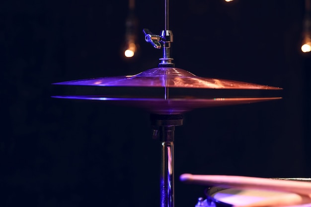 Part of a drum kit in the dark with beautiful lighting. Concert and performance concept.