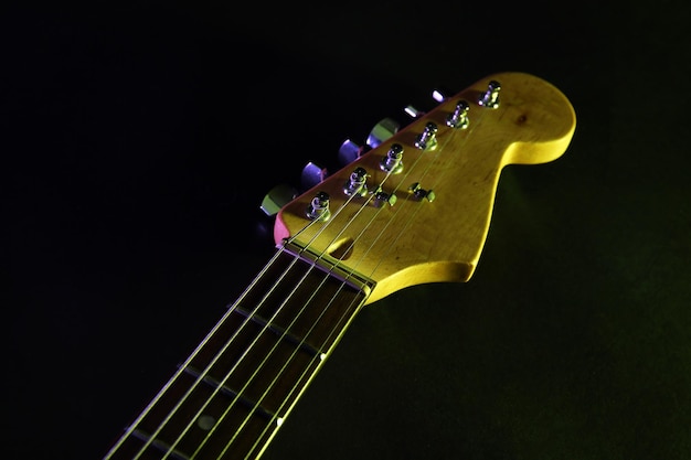 Part of electric guitar on dark lighted background