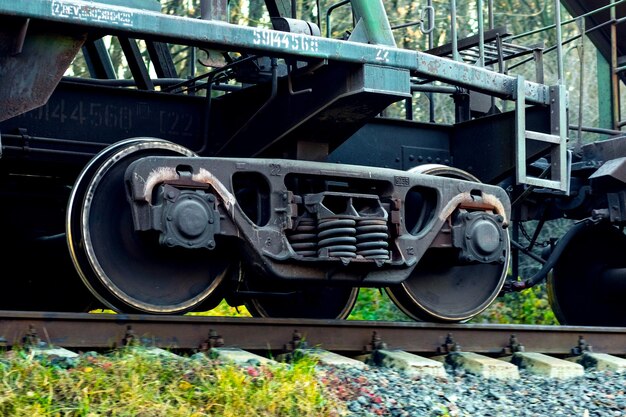 Photo part of a freight car with massive wheels during the movement of the train on the track