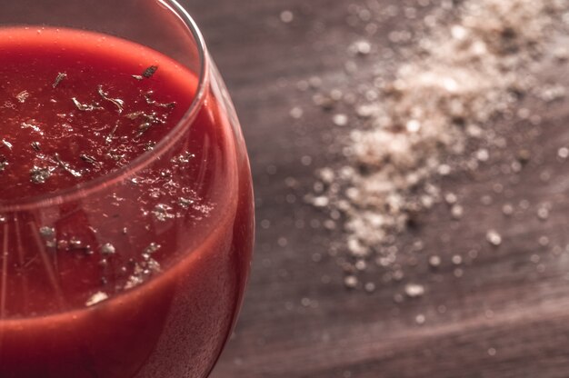 Photo part of a glass of tomato juice with spices and salt close up