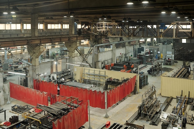 Part of interior of spacious factory with several plants or workshops