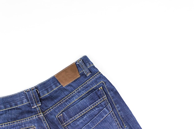 Part of jeans lying on white background. Copy space.