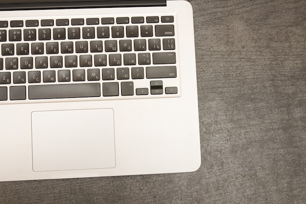 Part of the laptop keyboard on black wooden table.