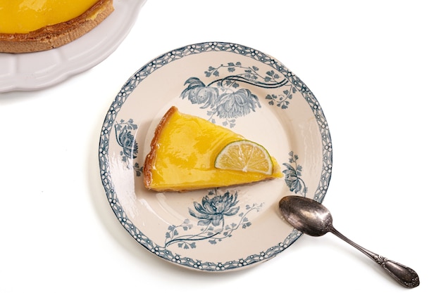 Part of lemon pie in an old plate on a white background