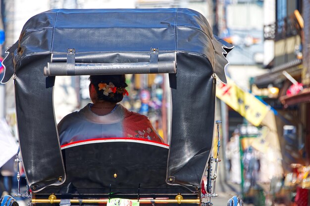 Photo part rear view of a pulled rickshaw with a woman inside