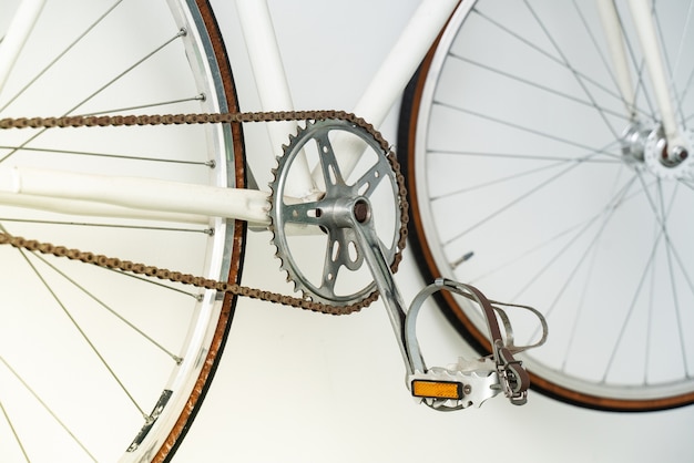 Part of retro bicycle hanging on the white wall 