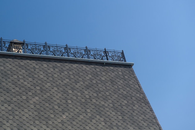 Part of the roof with tiles and metal fence