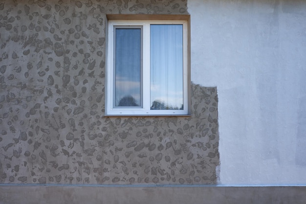 Part of the wall painted with white paint repair of the facade of the house Texture facade