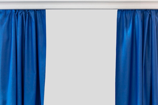 灰色で隔離されたテキストのためのスペースを持つコーニスの明るい青いカーテンを分けた