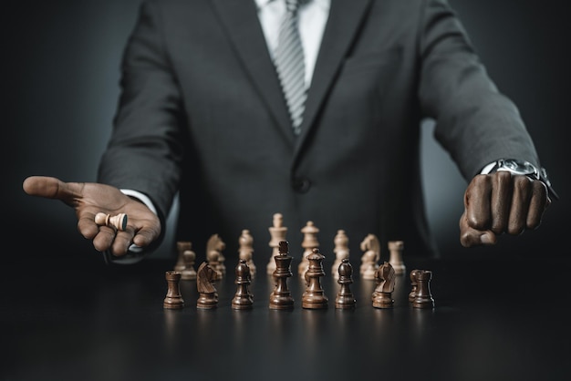 Partial view of african american businessman with chess figure in hand isolated on black