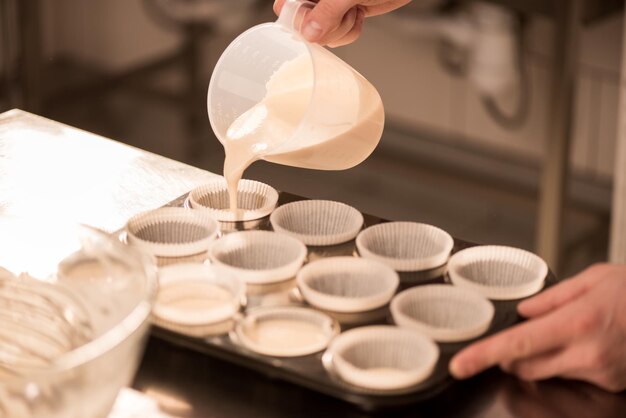 partial view confectioner pouring dough