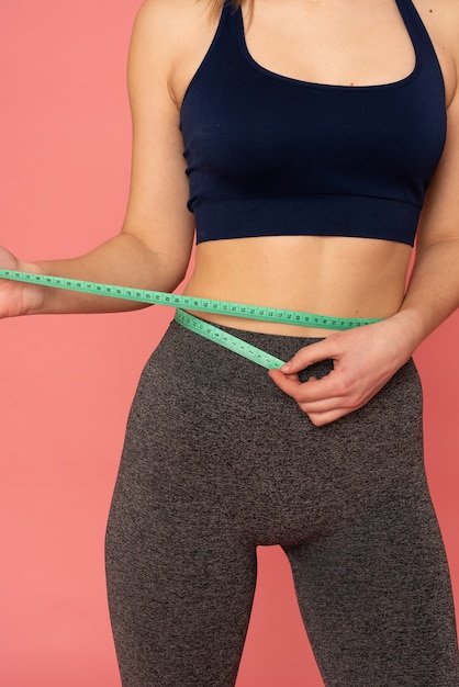 Partial view of european woman measuring waist