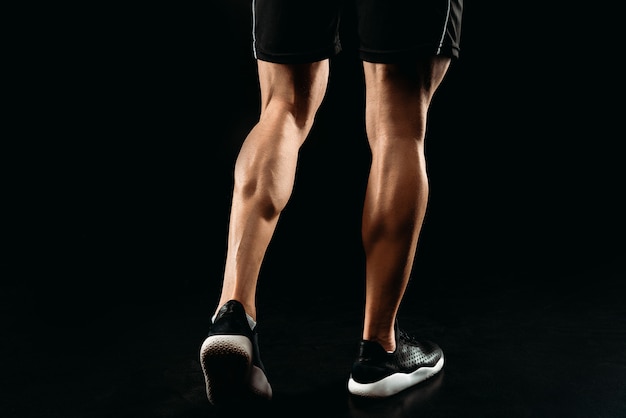 사진 근육질의 다리가 보디 블랙에 고립 된 포즈의 부분보기