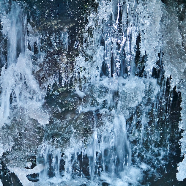 部分的にぼやけた背景-溶ける氷河のクローズアップの下で流れる水の流れ