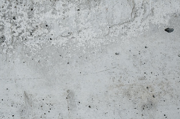 Partially smooth grey concrete texture riddled with holes from
escaping gases