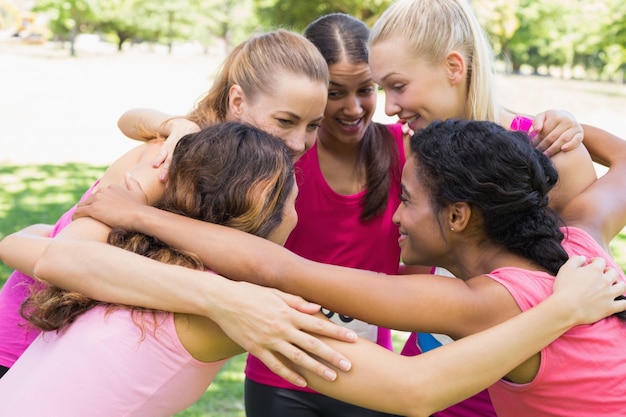 Participants of breast cancer marathon forming huddle