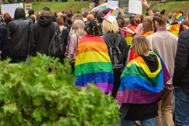 I partecipanti alla pride parade a kiev, in ucraina, camminano per le strade della città con bandiere e poster arcobaleno. una folla di giovani. concetto lgbtq.