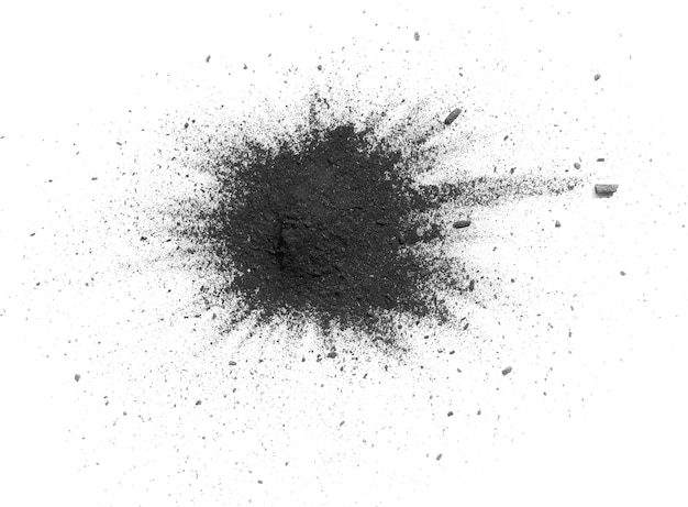 Foto le particelle di carbone schizzano su sfondo bianco. particelle di schizzi di carbone