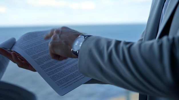 Partners discussing contract details at sea view Closeup hand pointing papers