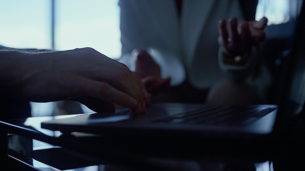 Partners hands work laptop at dark office closeup People talking gesturing