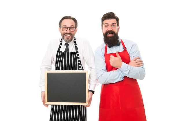 Partners vieren startmenu planning gelukkig chef-kok team in schort bebaarde mannen met schoolbord kopie ruimte café restaurant opening catering bedrijf welkom aan boord menubord leeg bord