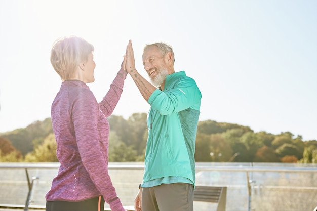 Partnerschap gelukkige familie paar volwassen man en vrouw in sportkleding geven high five na het hebben van