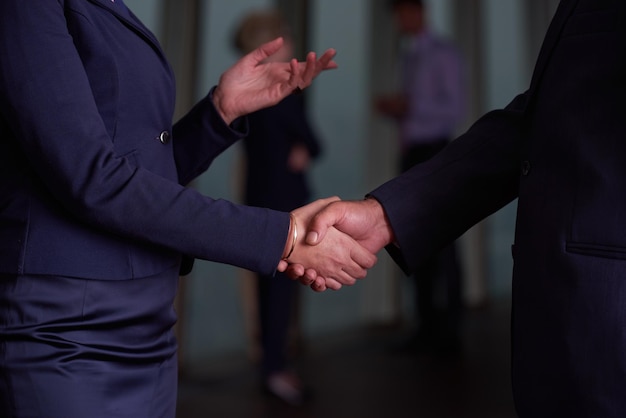 partnerschapsconcept met senior zakenman en -vrouw maken handbewegingen en sluiten een overeenkomst in modern kantoorinterieur