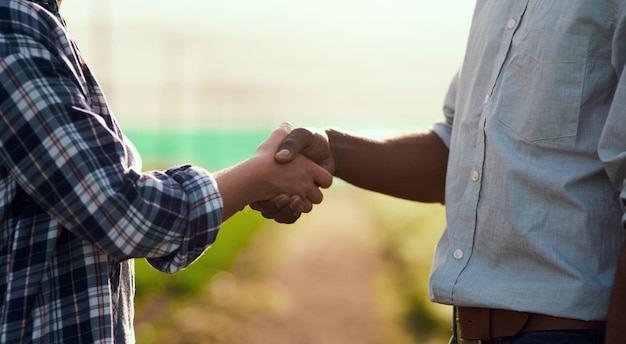 Partnership teamwork and unity by handshake two farmers starting organic trade together Sustainable farm owners meeting greeting entering a business deal Men collaborating with a goal or vision
