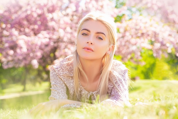 Partrait of sexy young woman lying on grass smiling face of spring girls