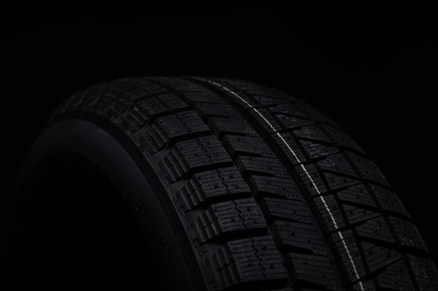 Parts of a black winter tire on a black background shot with depth of field