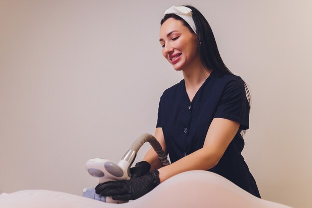 Parts of female body in special white suit having anti cellulite massage.